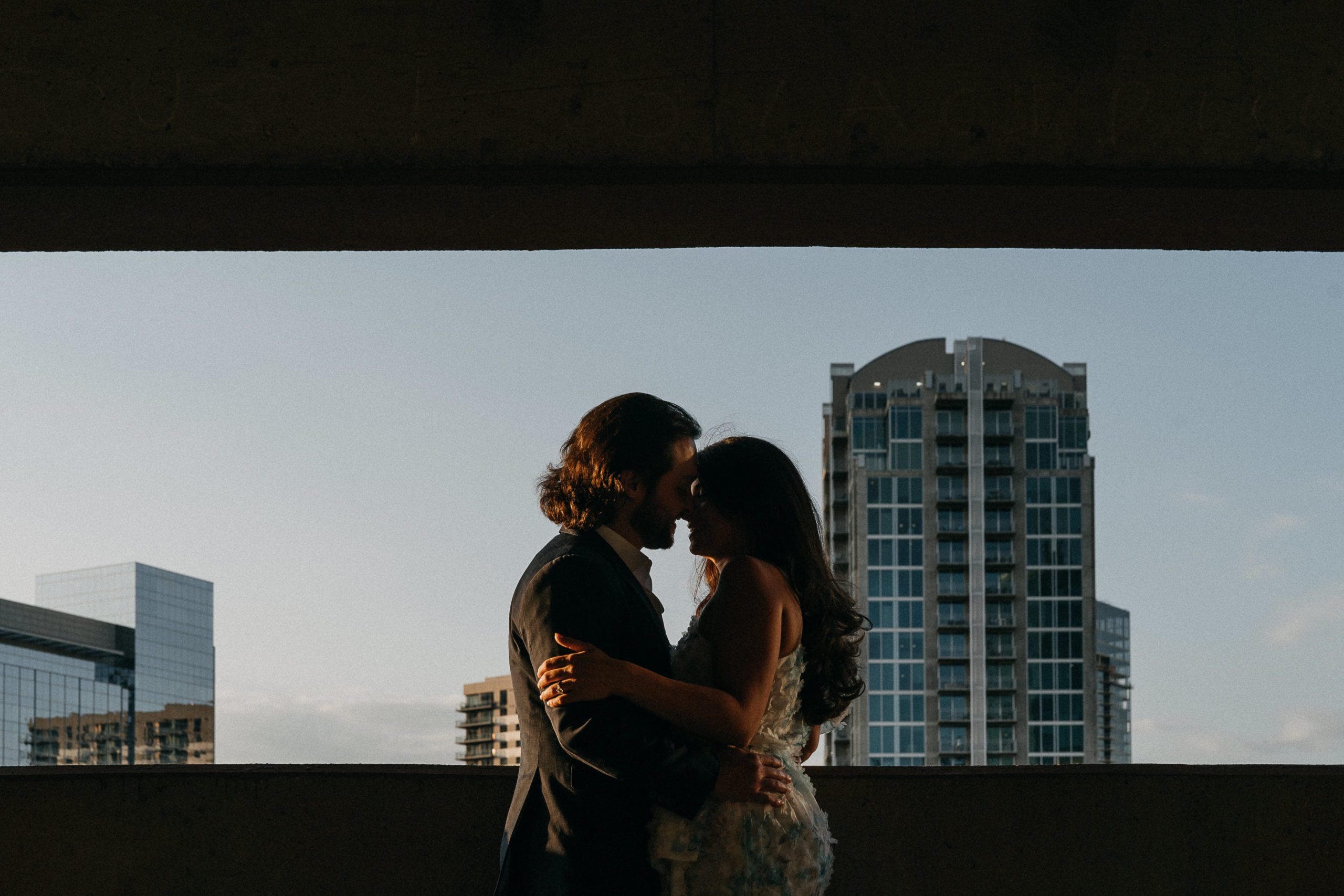 Engaged couple on a rooftop in Dallas Texas with the skyline visible, photographed by Hannah Hix