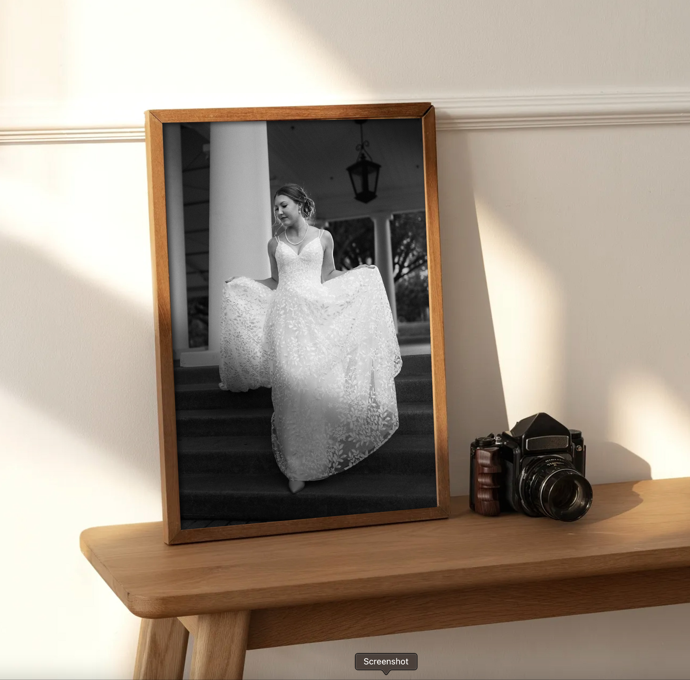 A framed photo sitting in sunlight with a camera sitting beside it