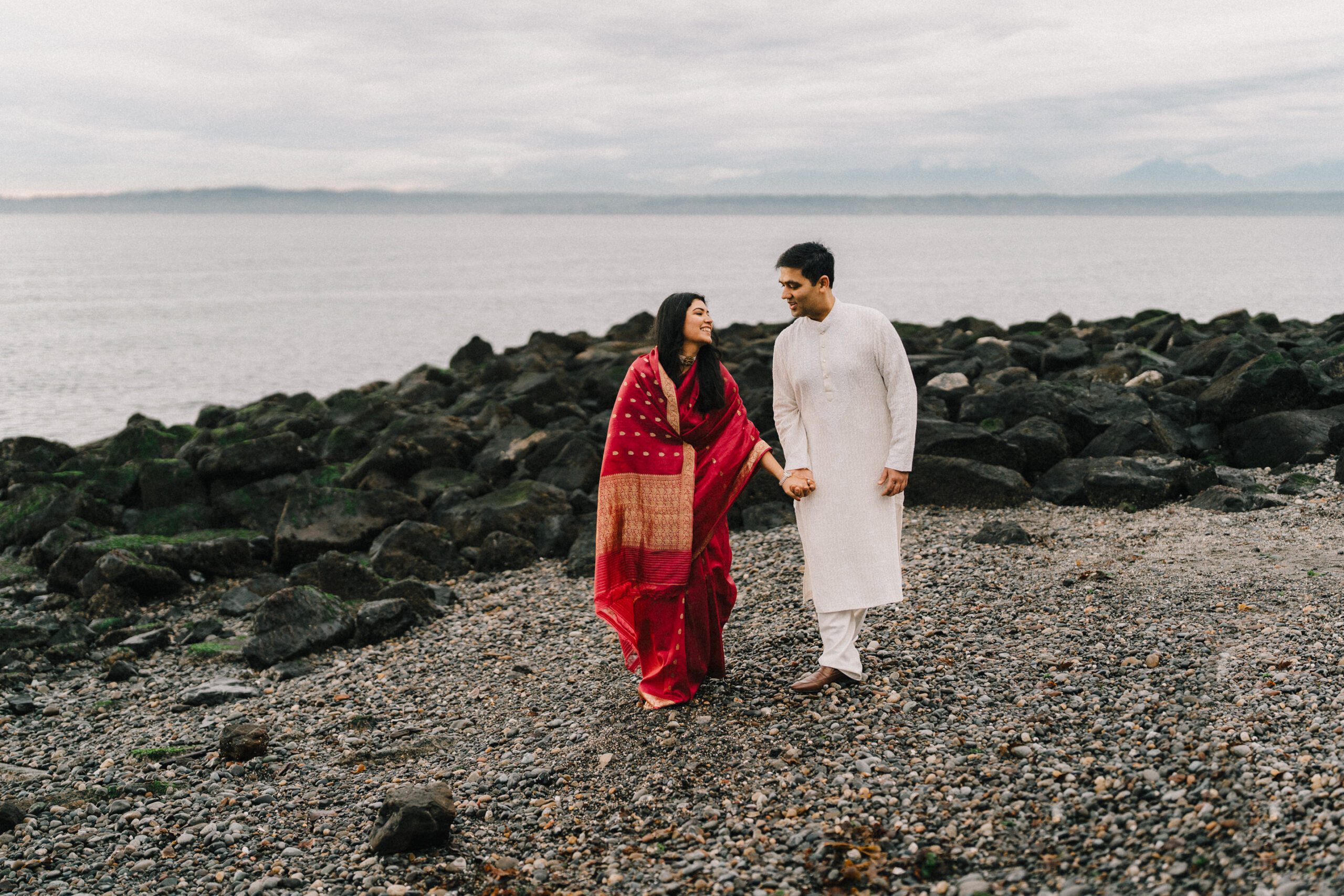 South indian couple walking candidly on the rocky shores of Seattle, Washington