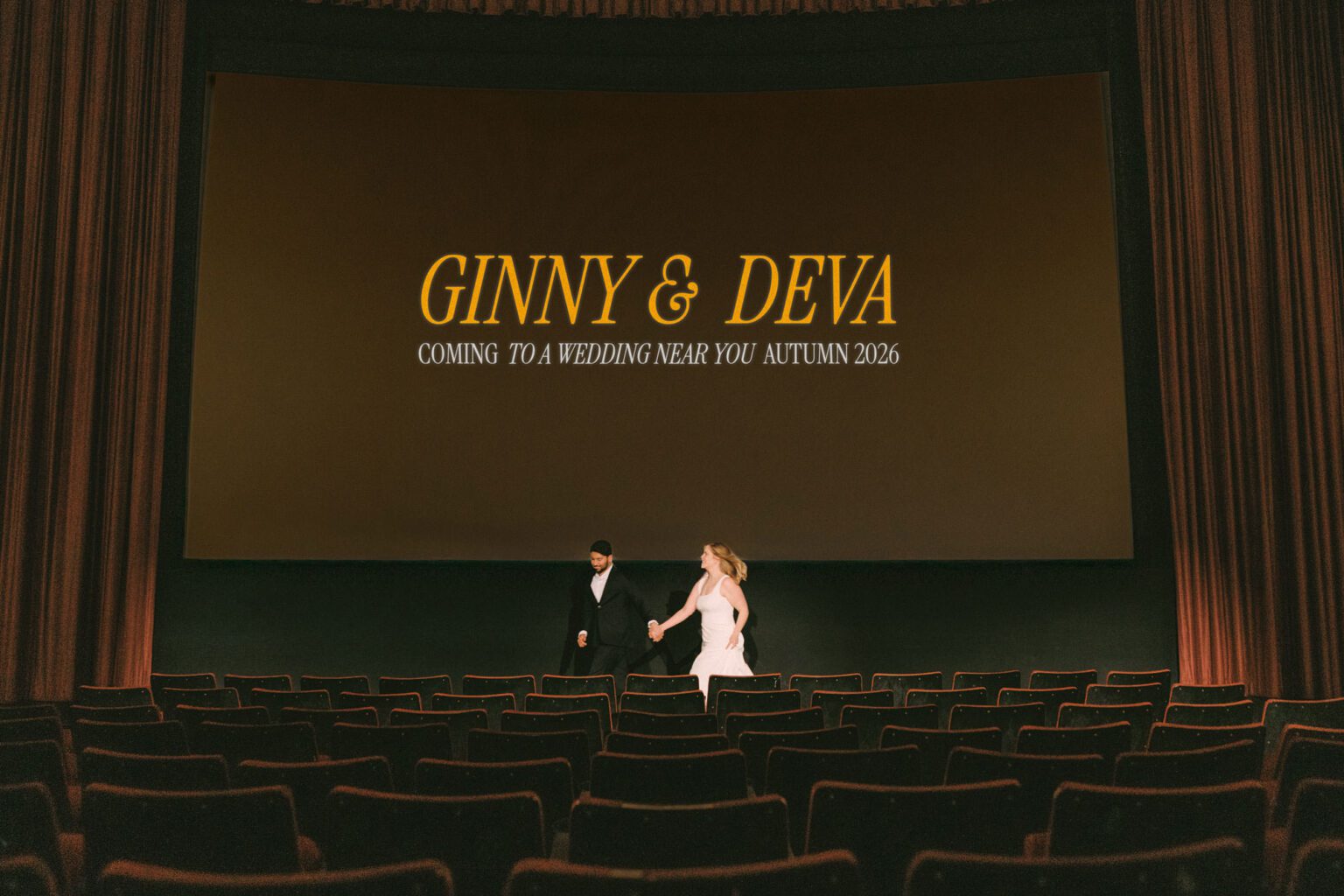 Engaged couple sitting together under the glow of theater lights at SIFF Cinema, Seattle engagement photographer